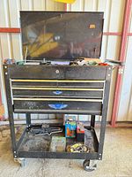 Full view of 5-drawer mobile cart with contents on bottom shelf