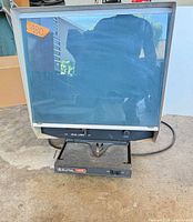 Front view of Bell & Howell ABR-IV microfiche reader showing screen, fiche carrier drawer and power cord