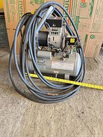 Full view of compressor with hose coiled around tank