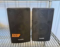 Front view of both Community speakers showing grills and branding