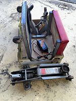 Floor jack, jack stands, rolling seat frame and charger grouped