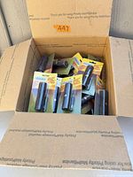 Open shipping carton containing multiple sealed Gordon mini 9-LED flashlights