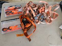 Overall lot with packaged straps and pile of loose straps