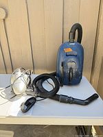 Kenmore canister vacuum with hose and curved wand beside Shark Euro-Pro X Turbo handheld vacuum