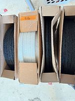 Four open cartons showing stacks of circular white pads