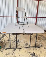 Two Lifetime folding tables with folding chair placed on top