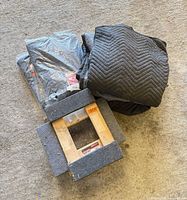 Two dollies stacked with loose blankets and sealed blankets beside