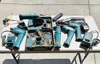 Overall view of drills, saw, chargers, batteries, toolbox and bits