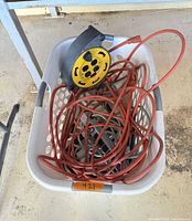 Basket containing cord reel and assorted cords