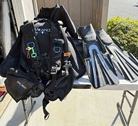 SeaQuest Balance BCD, fins and folded wetsuits on table