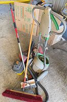 Group shot of vacuum, spreader, air tank, brooms, grease gun