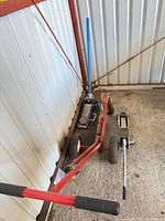 Red tailwheel transporter, blue jack, silver jack with handle on concrete floor