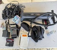 Overall view of all items including radio, multimeter, timer, air pump, adapters, flashlight and accessories on table