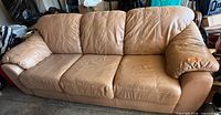 Front full view of tan faux leather three-seat sofa