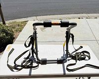 Front view of folded rack showing straps and foam pads