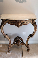Front view of carved giltwood console with marble top