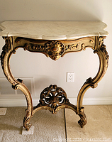 Front view of giltwood console with marble top and carved stretcher