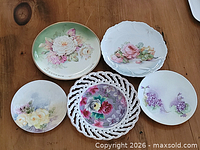 Group view of all five floral plates on wood surface