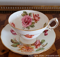 teacup on saucer showing rose pattern and gold trim