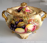 Front view showing fruit design, handles, feet