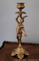 Front view of gold-tone metal figural candlestick