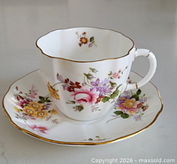 Teacup on saucer showing pattern, shape and gold trim