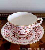 Teacup on saucer showing overall pattern and gold trim