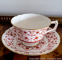 cup resting on saucer showing pattern and gilt trim
