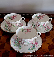 Three teacup and saucer sets displayed