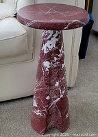 Full view of the red marble-look side table beside sofa