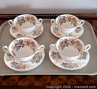 Set of four cups on saucers displayed on tray