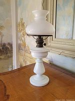 Full view of assembled lamp with shade showing glass body and burner