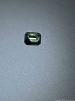 Top view of emerald-cut green-blue bicolored sapphire