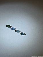 Four marquise sapphires arranged in a line on neutral background