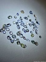 Group of mixed-cut tanzanite stones spread on surface