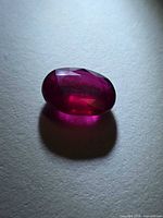 Top view of deep red oval ruby showing faceting and color
