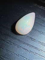 Pear cabochon fire opal on dark background