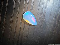 Front view of pear-shaped opal displaying play-of-colour