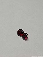 Pair of round faceted cherry red garnets