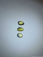 Three oval rose-cut sapphires laid vertically on light background