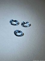 Three oval aquamarines top view showing color and cut