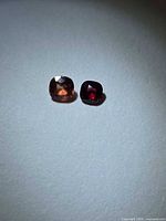 Both cushion-cut spinels side by side showing colour contrast