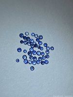 Loose round blue sapphires spread on neutral background