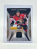 Front view of card showing Alfredsson image and jersey swatch