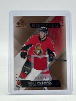 Front of Matt Puempel rookie patch card showing red jersey swatch and serial number 336/399