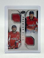 Front of card showing both players, jersey swatches and serial number 12/99