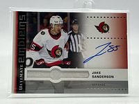 Front view of Jake Sanderson Ultimate Emblems autograph card in protector