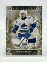 Front of card showing player image, dual jersey swatches, serial number 023/299