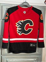 Front view of Calgary Flames youth jersey displaying crest and waist stripe