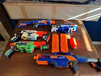 All five blasters, two magazines and missile on table